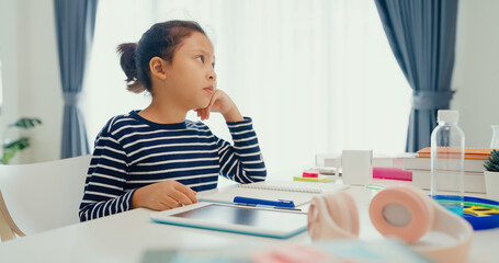 Asian toddler girl with sweater sit in front of desk with notepad use pencil focus on write...