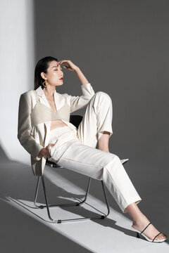 Fashionable young woman posing on chair