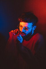 stylized portrait of a man with a beard and black modern glasses using 2 sources of colored light