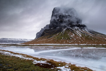 Lómagnupur mountain in Iceland with reflection and dramatic sky