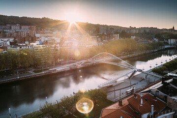 Bilbao cityscape and pedestrian Zubizuri bridge with backlit light in the early morning, Bilbao, Basque country, Spain.