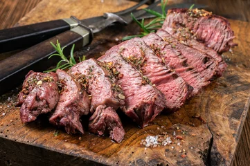 Foto auf Acrylglas Barbecue dry aged entrecote beef steak sliced and served as close-up on a rustic wooden board © HLPhoto