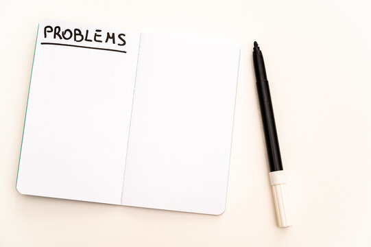 Blank notebook page, with the writing Problems, and marker next to it. Problems, solutions and answers.