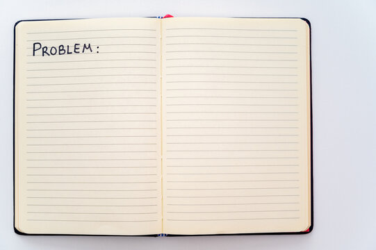 Blank notebook page, with the writing Problems, and marker next to it. Problems, solutions and answers.