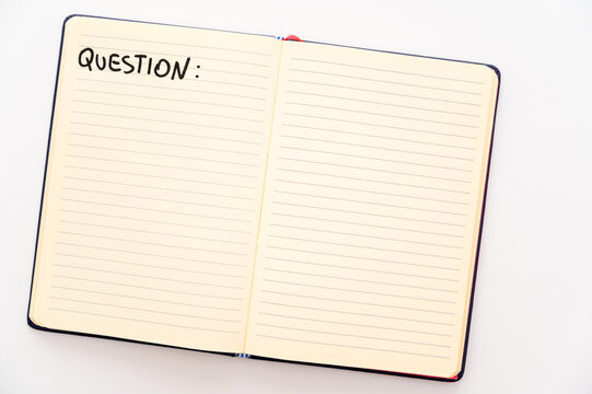 Blank notebook page, with the writing Questions, and marker next to it. Questions, answers and solutions.