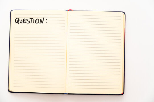 Blank notebook page, with the writing Questions, and marker next to it. Questions, answers and solutions.
