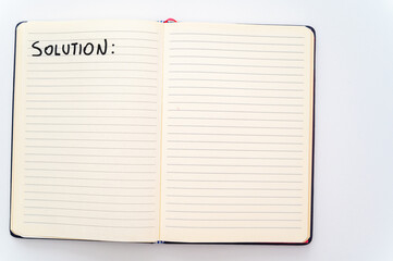 Blank notebook page, with the writing Solutions, and marker next to it. Solutions, problems and answers.