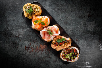 bruschetta set, various bruschettas with toppings on black plate