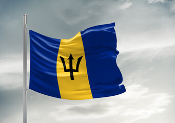 Barbados national flag cloth fabric waving on beautiful sky Background.