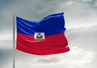 Haiti national flag cloth fabric waving on beautiful sky Background.
