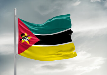 Mozambique national flag cloth fabric waving on beautiful sky Background.