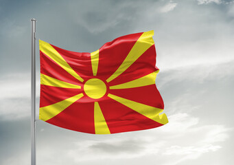 North Macedonia national flag cloth fabric waving on beautiful sky Background.