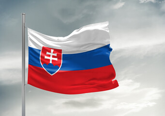 Slovakia national flag cloth fabric waving on beautiful sky Background.