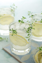 Glasses with lemon and thyme refreshing drink	