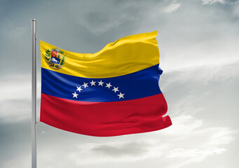 Venezuela national flag cloth fabric waving on beautiful sky Background.