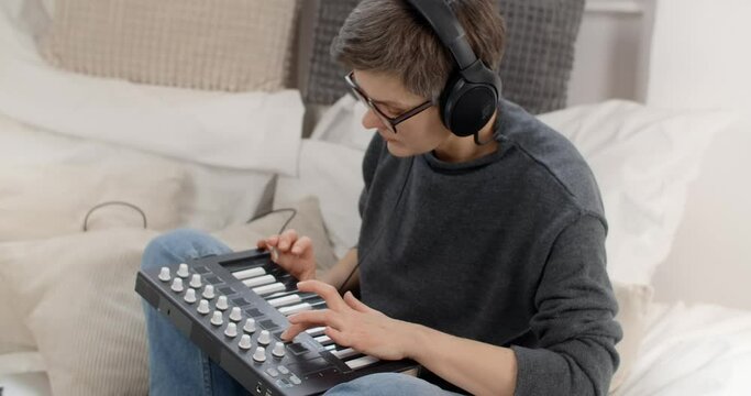 Creative Aged woman learns to play keys at home