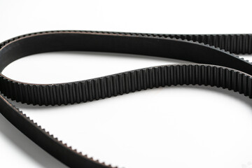 new spare parts for car repair, black engine timing belt on the table