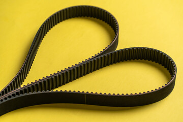 new spare parts for car repair, black engine timing belt on the table