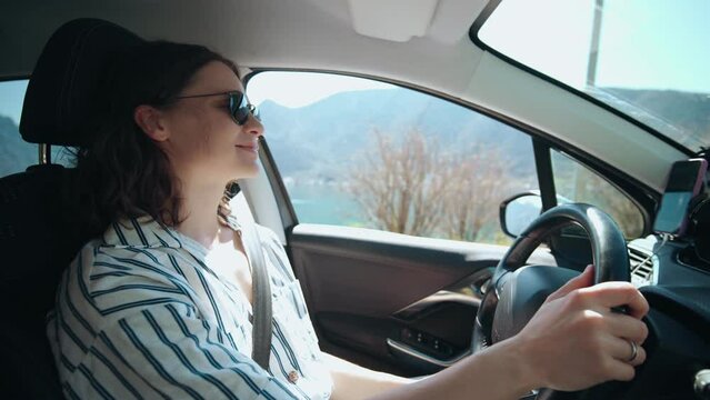 A young caucasian woman driving a car during her vacation to the sea.