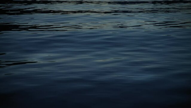 Cinematic static footage. Ripples on the sea surface at night