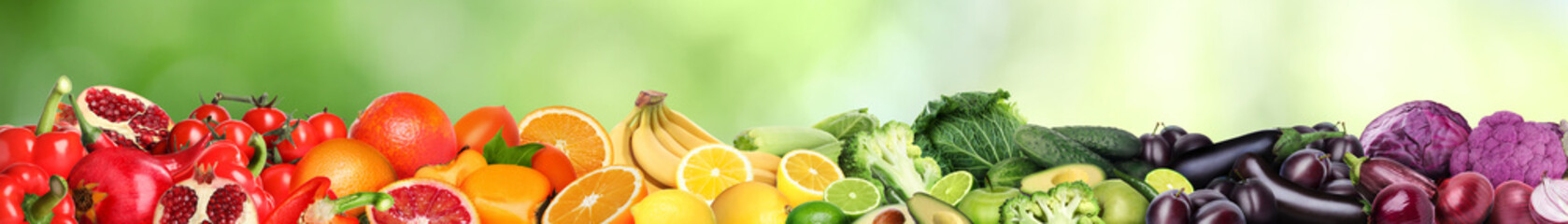 Many different fresh fruits and vegetables against blurred green background. Banner design