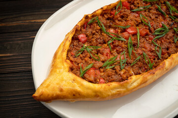 Savory meat pide on a white plate with traditional Turkish spices