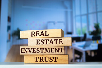 Wooden blocks with words 'real estate investment trust'. Business concept