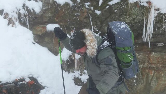 Trekker hiking in the snowy landscapes of Cozia National Park, Romania