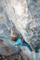A woman climbs a rock