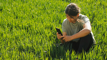 Girl on a meadow with a mobile.