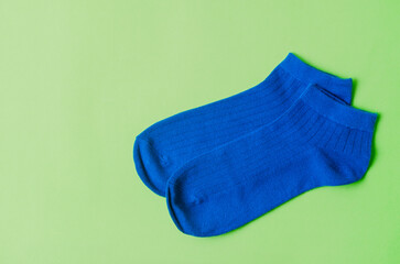 The Blue socks on green background, flat lay. Space for text