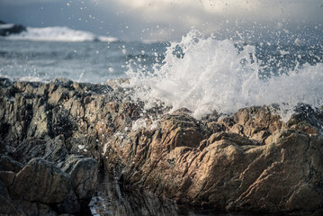 Closeup shot of stormy sea waves breaking on the shore with sea foam