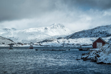 Beautiful shot of Kvaloya island, Norway in winter with a dock, and cabin in the background