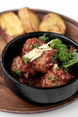 italian traditional beef meatballs with tomato sauce on wood board