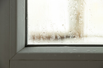Moisture and condensation on the window in the apartment, water on the glass close-up