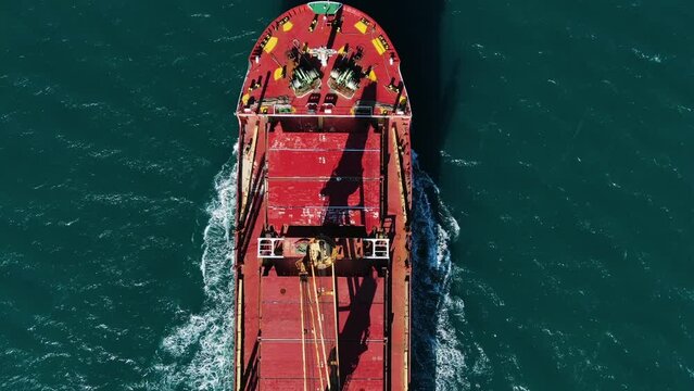 Top down view of a floating giant ship with petroleum products or grains in the middle of the sea or ocean