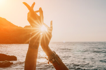 Woman sea yoga. Happy woman in white swimsuit and boho style braclets practicing outdoors on yoga...