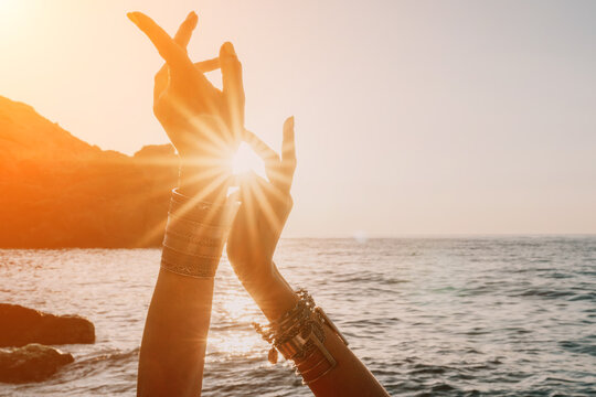 Woman sea yoga. Happy woman in white swimsuit and boho style braclets practicing outdoors on yoga mat by sea on sunset. Women yoga fitness routine. Healthy lifestyle, harmony and meditation