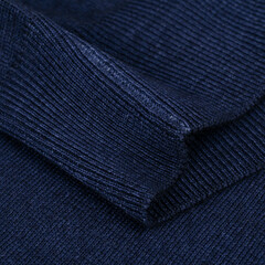 Knitted elastic band on navy blue wool jumper close up