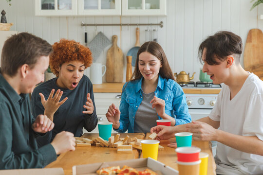 Home Party. Friends Spending Time Together Playing In Board Game Crash Wooden Tower At Home. Happy Diverse Group Having Fun Together Indoor. Mixed Race Young Buddies Best Friends Enjoying Weekend