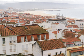 Obraz premium Top view of the streets with white houses and orange tiled roofs, an ancient portuguese city on the ocean