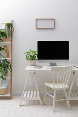 Spacious workspace with desk, chair, computer and potted plants at home