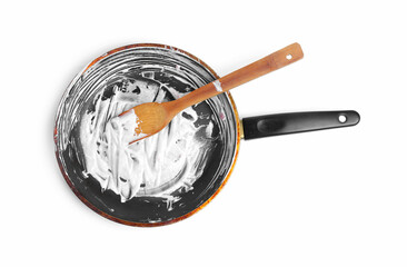 Dirty frying pan and wooden spatula on white background, top view