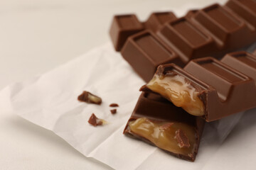 Tasty chocolate bars on white table, closeup. Space for text