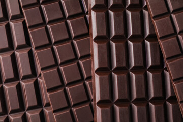 Many delicious dark chocolate bars as background, top view