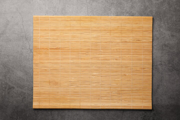 Bamboo mat on grey table, top view. Space for text