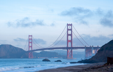 Golden Gate Bridge and the bay with mountains in the background on a foggy day