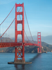 Vertical of the Golden Gate Bridge and the bay with mountains in the background