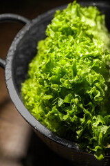 Fresh lettuce on brown table, closeup. Salad greens - obrazy, fototapety, plakaty