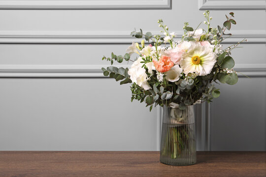 Bouquet of beautiful flowers on wooden table. Space for text